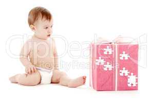 baby boy in diaper with big puzzle gift box