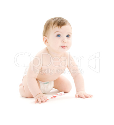 baby boy in diaper with toothbrush sticking tongue out