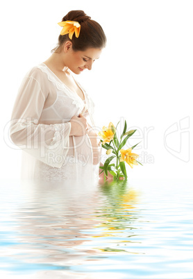 pregnant woman with yellow lily in water