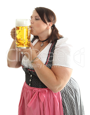 Frau im Dirndl küsst einen Maßkrug Bier