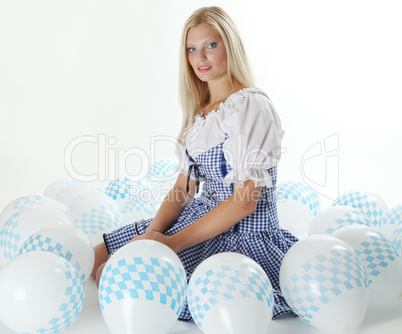 Blonde Frau im Dirndl mit bayrischen Luftballons