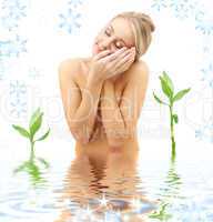 happy blonde with flower petals and green plants in spa