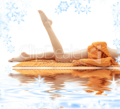 long legs of girl with orange towel on white sand