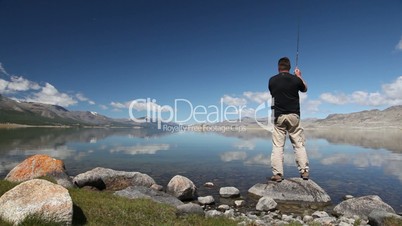 Fisherman with spinning catching fish in Khoton Nuur lake