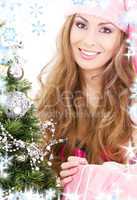 santa helper girl with gift box and christmas tree