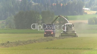 alfalfa harvest, combine and truck in field in British Columbia Canada