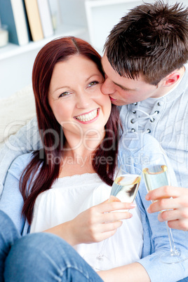 Attractive couple drinking champagne lying on the sofa