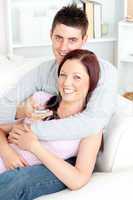 Portrait of an enamored couple watching television lying on the