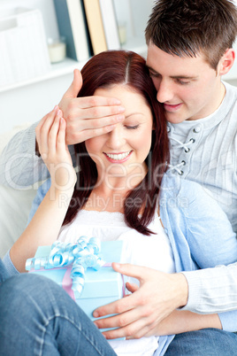 Kind boyfriend offering his pretty girlfriend a present in the l