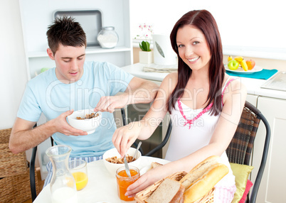 Young caucasian couple having breakfast together in the kitchen