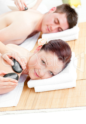 Relaxed young couple receiving a back massage with hot stones