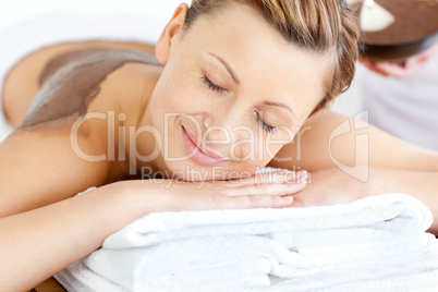 Relaxed young woman enjoying a beauty treatment with mud