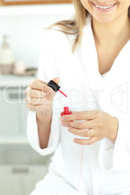 Close-up of a caucasian woman varnishing her fingernails in the