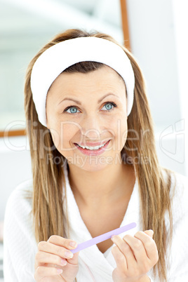 Joyful woman filling her nails in the bathroom