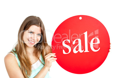 Bright young woman holding a red panel where "sale" is written