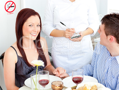 Joyful young couple dining at the restaurant