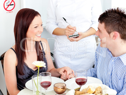 Smiling young couple dining at the restaurant