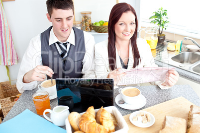Charming couple of businesspeople having breakfast in the kitche