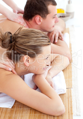 Jolly young couple receiving a back massage