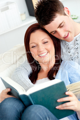 Happy couple reading a book in the living-room