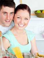 Smiling couple preparing spaghetti in the kitchen