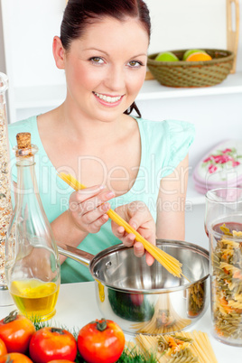 Charming woman cooking sphaghetti in the kitchen