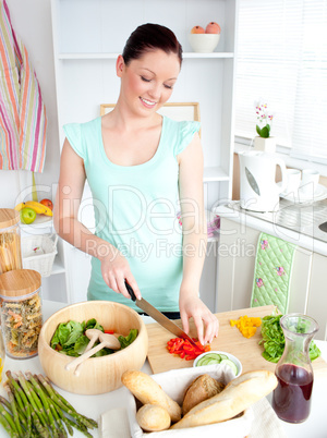 Joyful woman cutting pepper at home