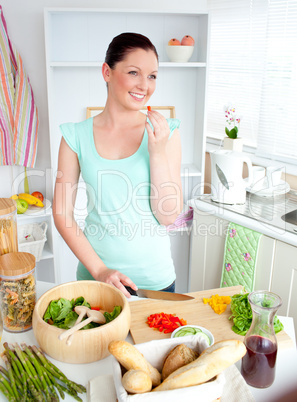 Bright woman cutting pepper at home