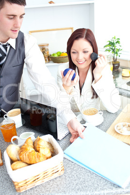 Couple of businesspeople having breakfast in the kitchen