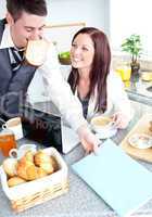 Cheerful couple ob businesspeople having breakfast in the kitche