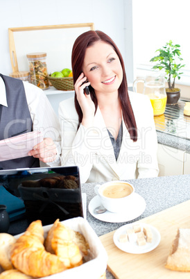 Serious couple of business people having breakfast in the kitche