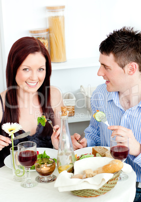 Smiling young couple dining in the kitchen