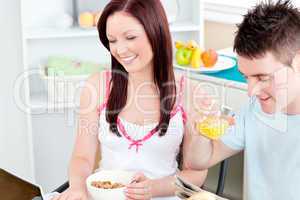 Bright couple using a laptop while breakfast