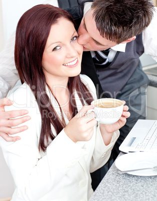 Attentive businessman kissing his bright girlfriend while having