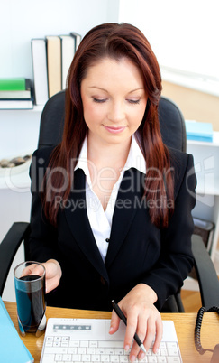 Bright businesswoman using her laptop in her office