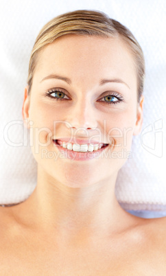 Portrait of a smiling young woman lying on a massage table