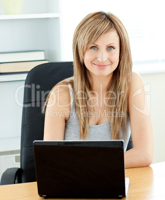 Charismatic young businesswoman using her laptop sitting at her