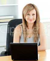 Charismatic young businesswoman using her laptop sitting at her