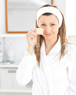 Attractive woman putting make-up on her face in the bathroom