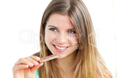 Young delighted woman eating chocolate