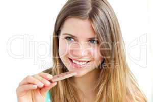 Young delighted woman eating chocolate