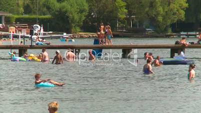 a warm summer day on the lake, kids on the pier, playing the water