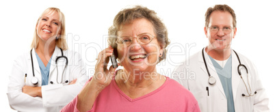 Happy Senior Woman Using Cell Phone and Doctors Behind