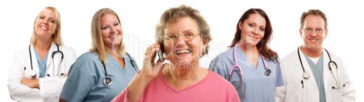 Happy Senior Woman Using Cell Phone and Doctors Behind