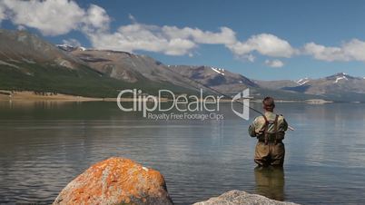 Fisherman with spinning catching fish in Khoton Nuur lake