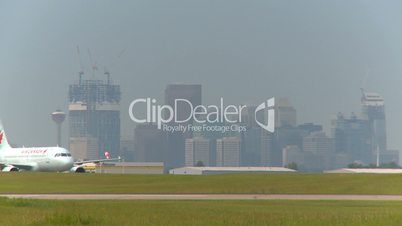 commercial jet taxis with city in Background