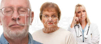 Concerned Senior Couple and Female Doctor Behind