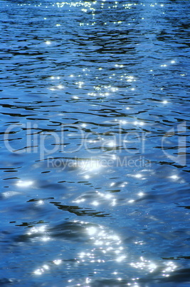 Lichtreflektionen auf einem See mit Wellen in Blau