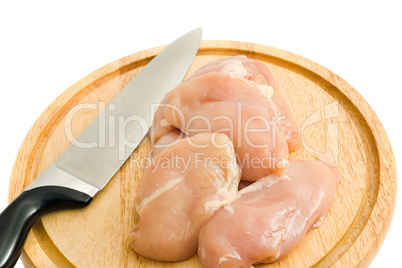 Chicken fillet and knife on hardboard isolated