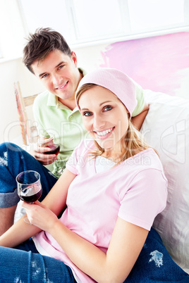 Joyful couple lying on the sofa after painting their new room